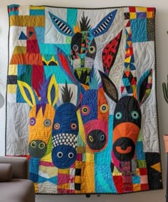 a colorful quilt hanging on the wall next to a chair