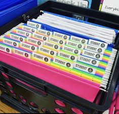 there are many folders in the bin on the desk and one is filled with them