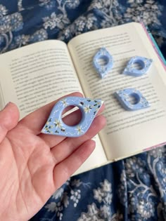 a hand holding an open book and some blue magnets