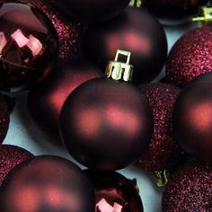 some shiny red christmas ornaments are laying on the ground