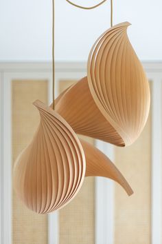 two wooden lamps hanging from strings in a room