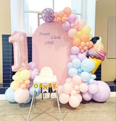 there is a table with balloons on it and a sign that says sweet little one