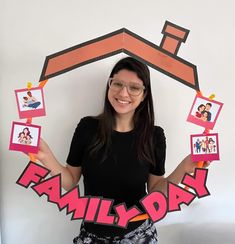 a woman is holding up family photos in front of her face and the word family on it