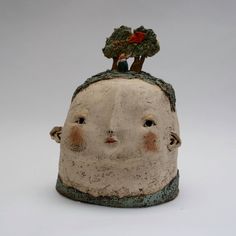 a ceramic head with a tree on top