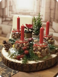 a wooden table topped with lots of candles and christmas decorations on top of glass jars