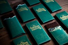 some chocolate bars sitting on top of a wooden table with green wrappers around them