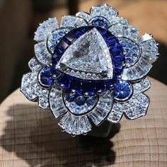 "Specification:- *Diamond Material : Cubic Zirconia *Center Diamond Cut : Trillion Cut *Center Diamond Dimension : 9.40 MM *Side Diamond Dimension : 1.10, 1.20,1.40, 3.00 MM *Side Diamond Weight : 0.89 CT *Diamond Color : White, Blue *Diamond Clarity : VVS *Making Process: Handmade by our Experienced Staff. *Stamp: Our All Rings Stamped According to metal Purity (925 SIL/10K/14K/18K). Custom Order:- *We do Accept Custom order. *Buyer can also request customization in listed Items (Charges apply Dazzling Diamond Sapphire Wedding Ring, Dazzling Sapphire Ring With Diamonds For Wedding, Dazzling Diamond Sapphire Ring For Wedding, Elegant Blue Diamond Flower Ring, Sapphire Cubic Zirconia Diamond Ring For Wedding, White Sapphire Ring With Diamond Accents For Wedding, Wedding White Sapphire Ring With Diamond Accents, Exquisite Blue Diamond Ring Gift, Sapphire Colored Diamond Wedding Ring In Fine Jewelry Style