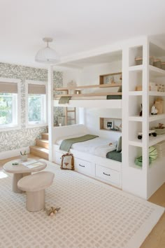 a bedroom with bunk beds and shelves in the corner next to a table on top of a rug