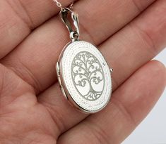 "Also available in gold plated/rose gold plated over sterling silver. This elegant customized oval locket will help you keep the memories of your loved ones afresh: 1. One shining, highly polished sterling silver locket. (19 x 26 mm, about the size of a quarter, 4.6 grams). Its front has an etched decorative border. Its back is plain. Both sides can be custom engraved with initial, text or simple graphics.  2. There are two photo slots. Photo insertion service is available for $14 each photo (pricing reflected in your pulldown option. If you select \" ... 1/2 photo\", please send your locket photos by attaching them to an ETSY conversation to me. 3. a sterling silver or gold filled cross pendant     Upgrade is also available:     https://www.etsy.com/listing/736367470 4. an optional custom Classic Locket Jewelry As A Gift, Classic Locket Necklace With Charms For Gift, Oval Locket Necklaces For Anniversary, Oval Locket Jewelry For Gift, Oval Locket Necklace For Anniversary Gift, Nickel-free Oval Pendant Locket Necklace For Keepsakes, Elegant Medallion Locket Necklace For Anniversary, Heirloom Engraved Jewelry For Anniversary, Nickel-free Oval Pendant Jewelry For Keepsake