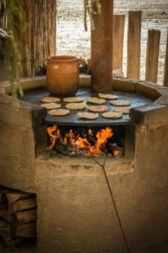 an outdoor fire pit with food cooking on it