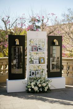 two black and white framed pictures are on display with flowers in front of the frames