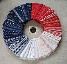 an assortment of different colored fabrics arranged in a circle on top of a tablecloth