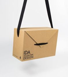 an open cardboard box with a black ribbon hanging from it's front and side