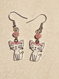 White enamel kitty charm with pink bangs and ear, and 6mm pink accent bead Adjustable Pink Kawaii Jewelry, Adjustable Pink Enamel Jewelry, Whimsical Nickel-free Pink Earrings, Whimsical Pink Nickel-free Earrings, Pink Novelty Dangle Jewelry, Pink Adjustable Hand Painted Jewelry, Adjustable Hand Painted Pink Jewelry, Playful Pink Enamel Jewelry, Cute Personalized Enamel Jewelry