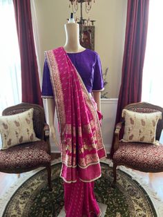 "A beautifully re-designed vintage Banarasi silk saree in rani pink color with a thoughtfully finished underside in deep purple raw silk material. This exquisite saree is further detailed with a subtle pearl lace to revamp the elegance of this stunner! This is truly a classic piece given new life for all ages to wear! The princess-cut stitched (38\" bust) purple raw silk blouse is also adorned with pearl on sleeves, with a high front neck and full back with hooks! Please note: these sarees are r Bollywood Style Purple Raw Silk Pre-draped Saree, Purple Silk Pre-draped Saree With Zari Weaving, Traditional Purple Silk Pre-draped Saree, Purple Silk Pre-draped Saree In Traditional Style, Purple Silk Pre-draped Saree Traditional Drape, Purple Slub Silk Traditional Wear, Traditional Purple Slub Silk Saree, Slub Silk Purple Traditional Wear With Pallu, Purple Slub Silk Saree With Traditional Drape