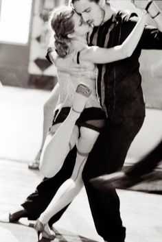 a man and woman are dancing on the street