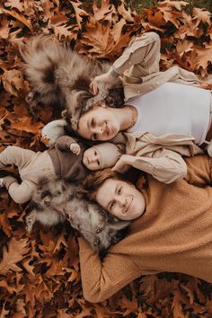 three women laying on the ground with leaves all around them