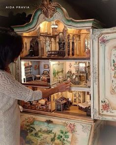 a woman is looking at an elaborate cabinet