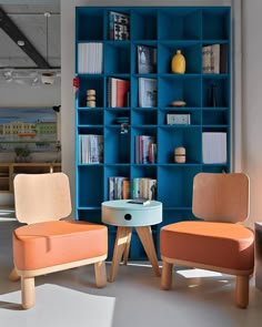 two chairs and a table in front of a bookshelf