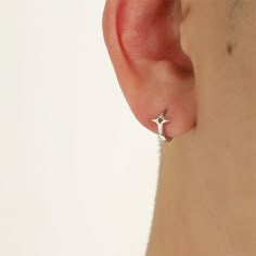 a close up of a person's ear with a small silver star on it