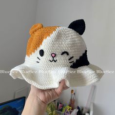 a hand holding up a crocheted cat hat