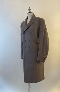 "Well tailored double breasted wool coat by Morty Sills has covered buttons in the front, on the cuffs and in the back. Coat is lined in a taupe satin and has two inside pockets, slight shoulder pads and a back kickpleat. In excellent vintage condition The Morty Sills brand has been referred to as \"the tailor to the CEO\". Morty Sills specialized in high-end formal/semi-formal wear for men and women. Handcrafted in the USA. Shoulders 17\" Chest 40\" Waist 36\" Hips 42\" Length from back of neck Formal Double-breasted Pea Coat With Button Cuffs, Formal Wool Pea Coat With Button Cuffs, Gabardine Pea Coat With Button Closure For Formal Occasions, Elegant Pea Coat With Button Cuffs And Lapel Collar, Formal Gabardine Pea Coat With Double Button Closure, Formal Gabardine Pea Coat With Button Closure, Elegant Tailored Pea Coat With Button Cuffs, Formal Double-breasted Outerwear With Buttons, Elegant Double-breasted Pea Coat With Button Cuffs