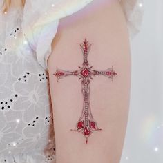 a woman's arm with a cross tattoo on the left side of her arm