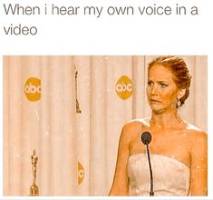 a woman standing at a podium with an award in front of her and the caption reads, when i hear my own voice in a video