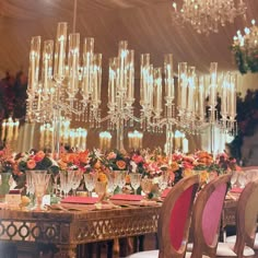 a fancy dining room with chandelier and flowers