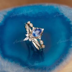 a blue ring with diamonds on it sitting on top of a blue plate in the middle of a bowl