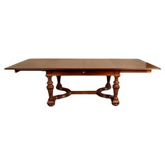 a large wooden table with two leaves on the top and one leaf at the base