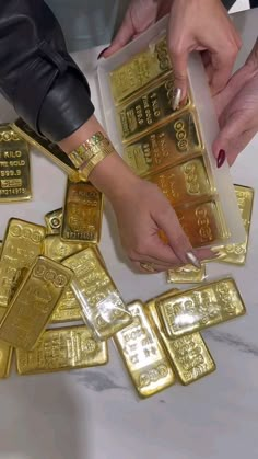 several people holding gold bars in their hands and touching one another's fingers with the other hand