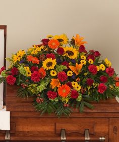 an arrangement of flowers in a wooden casket