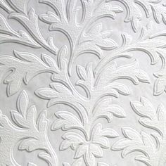 the white wallpaper has an intricate design on it's back side and is decorated with leaves