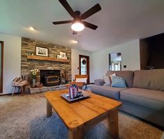 a living room with a couch, coffee table and ceiling fan in it's center