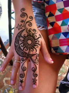 a woman's hand with a henna tattoo on it