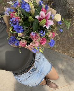 a woman is holding a bouquet of flowers