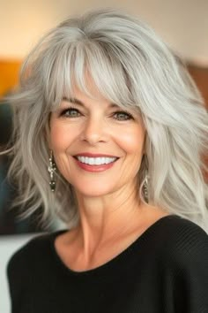 Save this pin for the best medium-length hairstyles for women over 50 with bangs. Take a trip to your wild side with this fun and edgy cut. Choppy layers create noticeable volume. Ask your stylist for lots of layers and point-cutting to get that imperfect look. Bangs Over 50, Women Over 50 With Bangs, Over 50 With Bangs, Medium Length Hair With Bangs, Grey Hair Looks, Bangs Ideas, Medium Shag, Gray Hairstyles, My Haircut