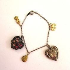 "Adorable bracelet! Two gold-tone vintage lockets are attached to a silver-tone chain, along with a silver-tone locket enameled in peach. There are two charm accents - an elephant and a cat. Too cute! Unsigned, very good condition. Measures 6 3/4\" in length." Vintage Metal Heart Charm, Vintage Metal Heart Charms, Vintage Heart Charm Dangle Jewelry, Antique Metal Jewelry With Heart Charm, Vintage Heart Charm Bracelet As A Gift, Vintage Heart-shaped Bracelets With Charm, Heart Shaped Vintage Bracelets With Vintage Charm, Vintage Heart-shaped Bracelet With Charm, Vintage Heart Charm Bracelet For Gift