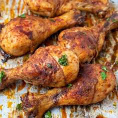 some chicken legs are sitting on a baking sheet