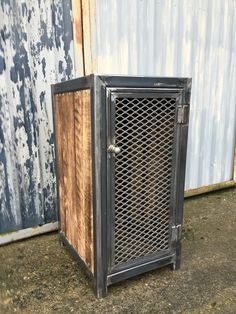 an old metal and wood crate sitting in front of a building