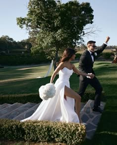 a man in a tuxedo and a woman in a white dress are walking