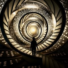 a man standing in the middle of a spiral stair case with lights shining down on it