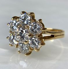 A vintage elegant and classic all genuine 14k yellow gold ring featuring a flower made of 7 round cubic zirconia (CZ). The ideal gift for her: Birthday, graduation, engagement, promise ring, push present, mother's day valentine's day Christmas and anniversary. Classic 14k Stamped Flower Promise Ring, Classic Flower Shaped Diamond Ring For Anniversary, Classic 14k Stamped Flower Ring For Anniversary, Classic 14k Gold Flower Ring, Classic 14k Gold Flower Ring For Formal Occasions, Classic Vvs Clarity Cluster Ring, Classic Flower Shaped Diamond Promise Ring, Gold Cluster Ring With Flower Shape And Prong Setting, Classic Cluster Cubic Zirconia Ring