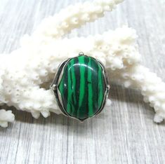 Vintage fashion jewelry, Malachite imitation woman's ring in size 9.Only 1 item available, not adjustable and not resizeable. Very good condition.Size: 9 ( US and Canada ), R 3/4 ( UK and Australia ), 19 ( Europe ).Stone: stripy green MAlachite imitation ( AKA pressed stone or reconstituted malachite )The stone is oval shape, measuring 14X10 mm and standing 7 mm tall over the finger surface.Material: Silver plated brass.This is a high quality ring in electric silver plate with 980 silver that la Adjustable Turquoise Gemstone Ring, Adjustable Green Turquoise Gemstone Ring, Handmade Adjustable Green Turquoise Ring, Adjustable Vintage Green Rings, Green Vintage Adjustable Rings, Handmade Green Jewelry For Collectors, Green Turquoise Ring For Jewelry Making, Adjustable Green Malachite Jewelry, Green Crystal Round Ring As Gift