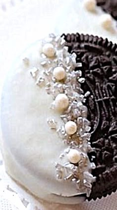 an oreo cookie decorated with white and black icing on a doily cloth