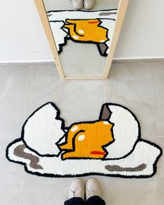 a person standing on the floor in front of a door with a cartoon cat rug