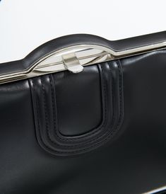 This stunning accessory features a classic black design that’s perfect for adding a touch of elegance to any outfit. With its stylish attached top handle and a removable crossbody strap, you can easily switch between chic and casual looks in an instant. The secure top snap closure keeps your essentials safe, while two inner zip pockets and one slip pocket offer ample organization for your treasures.Available while supplies last. Timeless Black Bag With Round Handle, Elegant Workwear Bag With Fold Over Clasp, Timeless Black Shoulder Bag With Round Handle, Timeless Black Satchel With Detachable Strap, Sleek Bags With Metal Hardware For Everyday Use, Sleek Everyday Bags With Metal Hardware, Sleek Evening Bags With Metal Hardware, Elegant Satchel With Metal Hardware And Round Handle, Timeless Black Bag With Detachable Handle