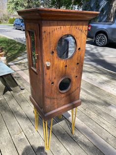 an old wooden bird house with holes in the front and sides on it's legs