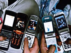 four cell phones are being held in the palm of someone's hand, with pictures on them